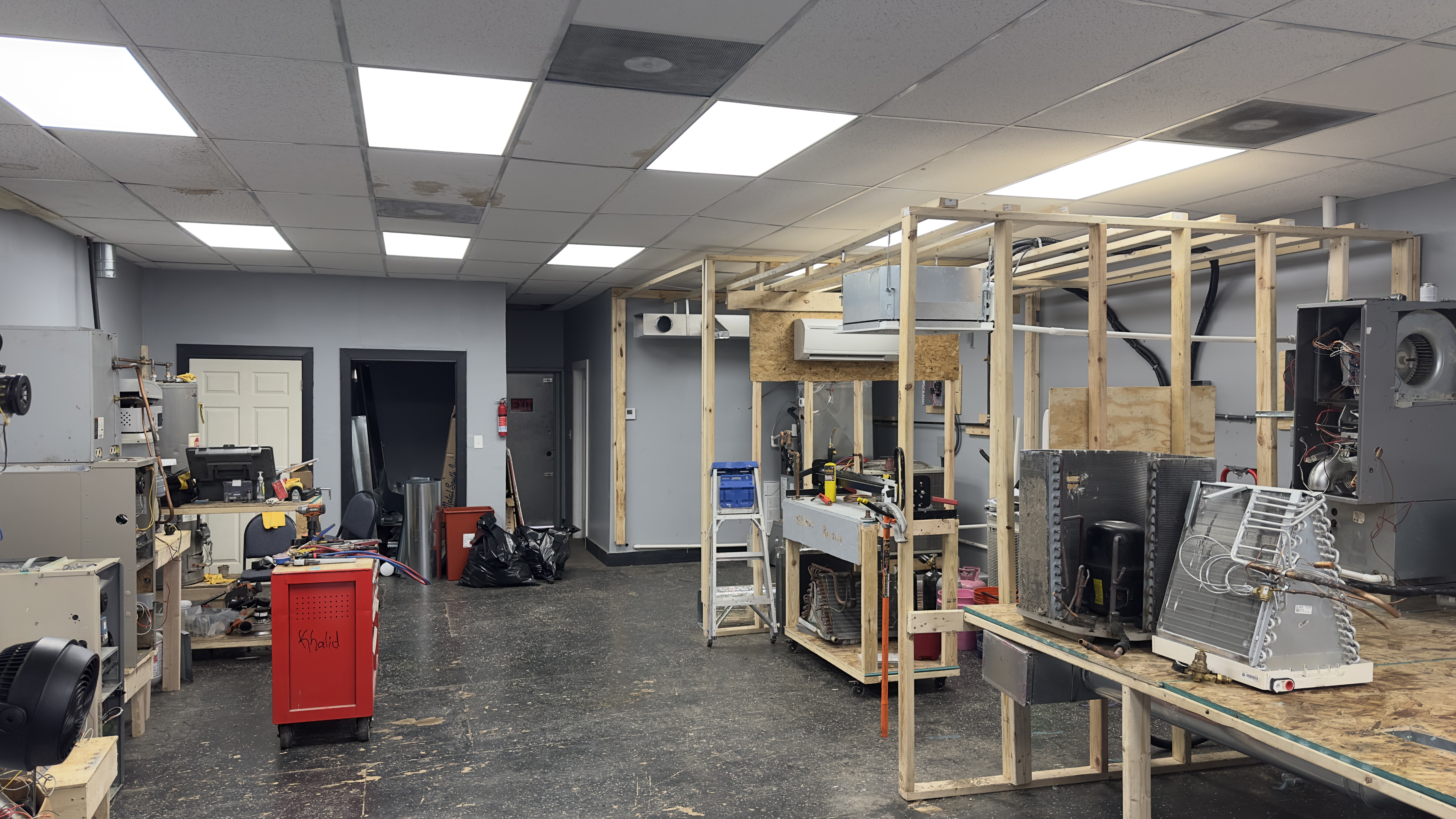 Bliss Global Corp. hands-on HVAC training lab at 233 E. 115th Street, Roseland, Chicago — custom-built equipment rigs, condensers, air handlers, and workbenches